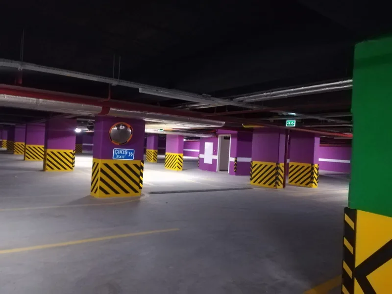 Mor ve sarı boyalı kolonlarıyla bodrum kat otoparkı