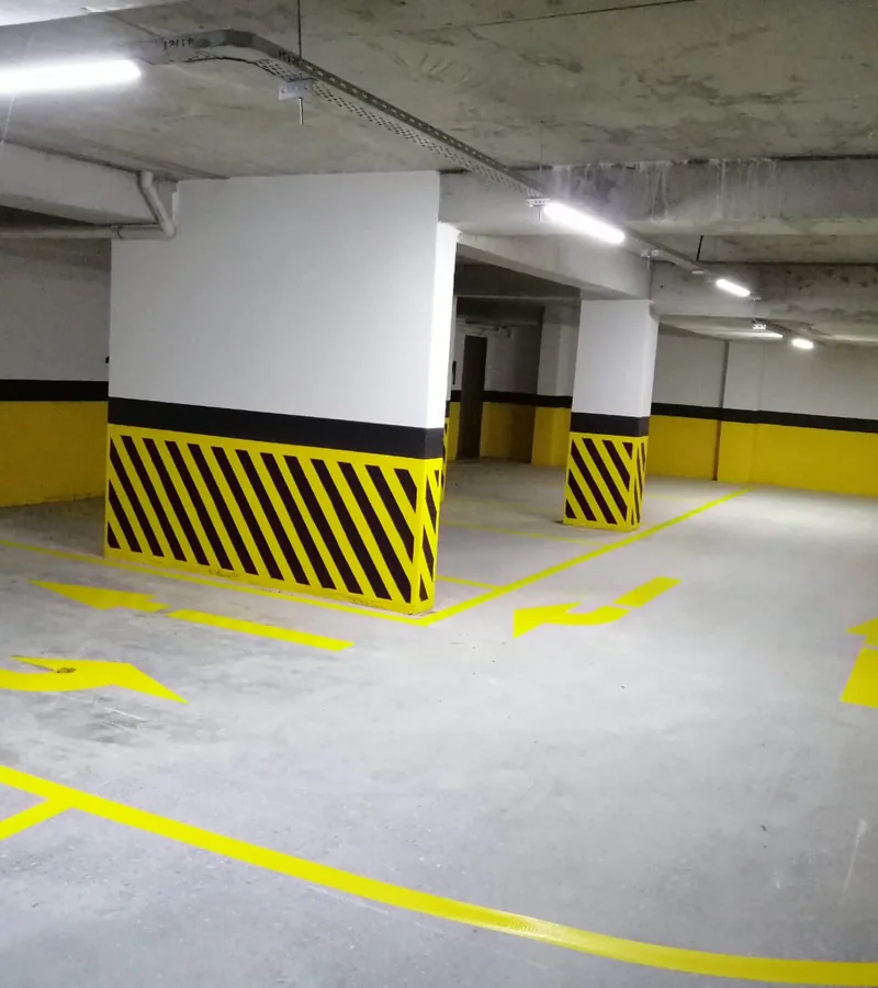 Sarı yön okları ve park çizgileri çizilmiş parlatılmış otopark zemini