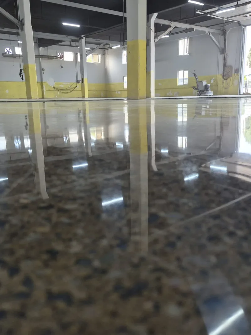 Pencere ve tavan ışığını yansıtan parlatılmış beton yüzey