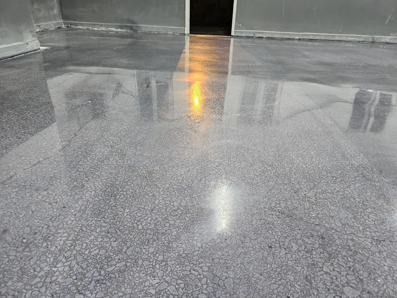 Armatür ışıklarını yansıtan gri tonlu parlatılmış beton zemin